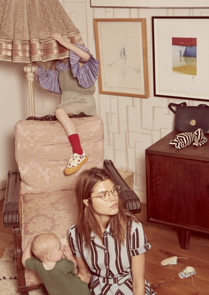 Ava hiding under the lamp wears Dress by Tocoto Vintage, stripe top worn under by Paade Mode, shoes by Bobo Choses X Novesta from Smallable, socks by Roseanna. Jordan wears stripe dress by Tara Jarmon, clear glasses by Rayban. Baby Daisy wears jumpsuit by Oeuf NYC