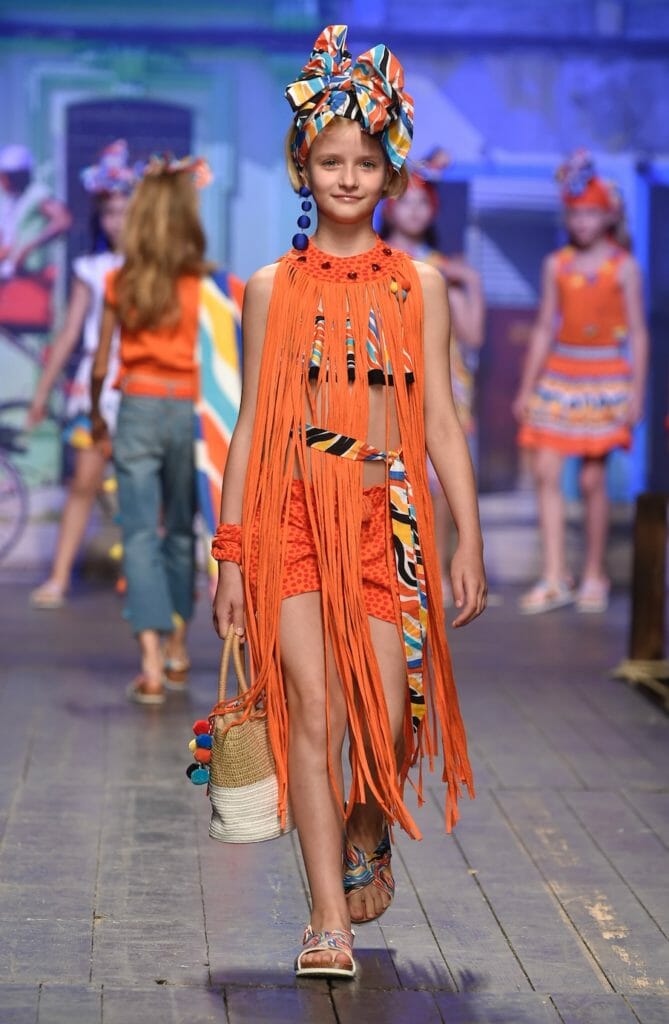 Hot orange, Latin American styling and fringing at TucTuc in the childrens fashion from Spain catwalk at Pitti Bimbo 87 for SS19